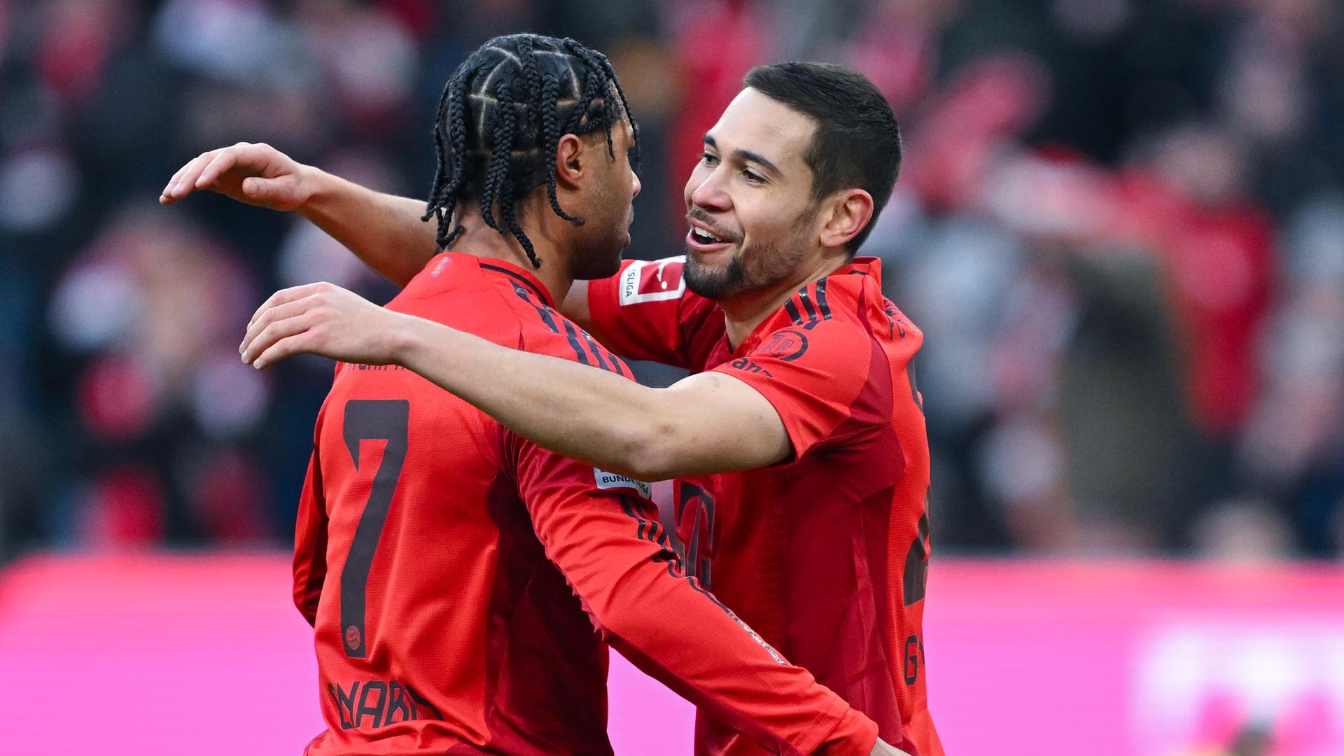 Bayern-Spieler Serge Gnabry (l) jubelt mit Raphael Guerreiro über sein Tor zum 4:0.