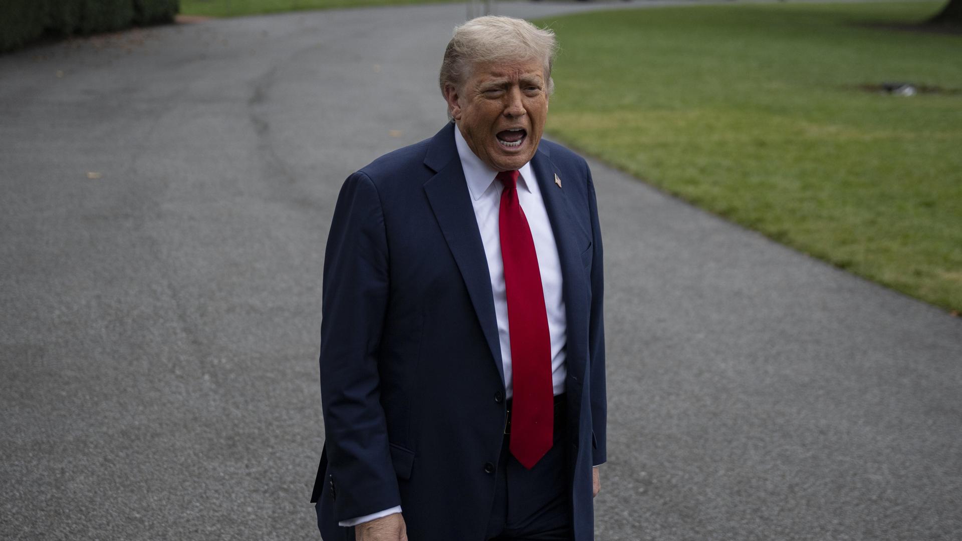 Donald Trump steht auf einem Weg vor dem Weißen Haus und schreit in die Kamera Donald Trump steht auf einem Weg vor dem Weißen Haus und schreit in die Kamera
