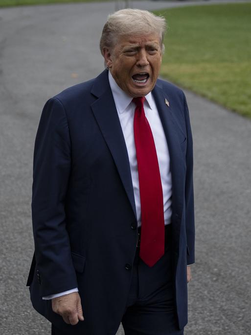 Donald Trump steht auf einem Weg vor dem Weißen Haus und schreit in die Kamera