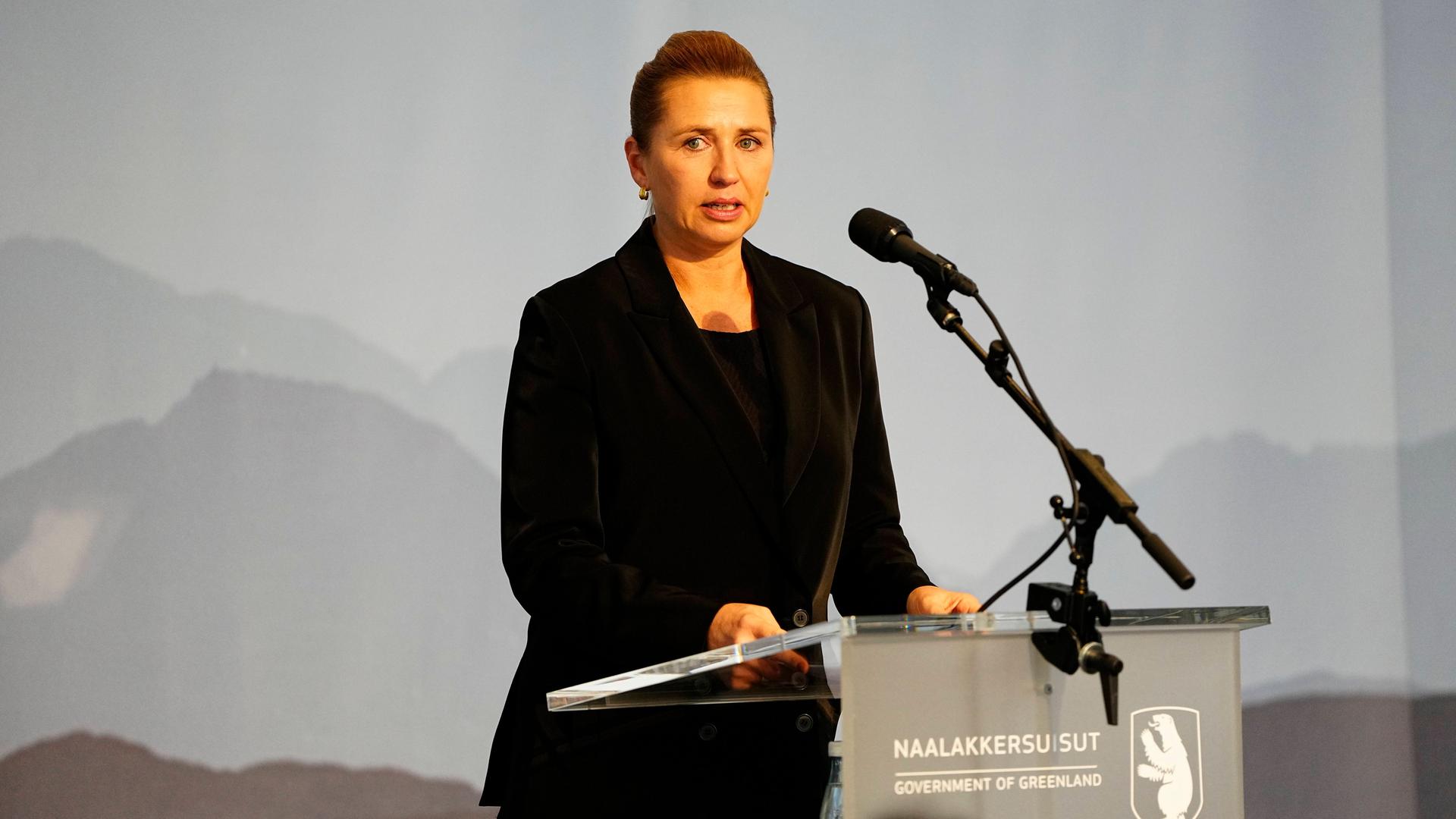 Die dänische Regierungschef Frederiksen spricht in einem Versammlungsraum in der grönländischen Hauptstadt Nuuk. Sie hat schwarze Kleidung an. Vor ihr steht ein Mikrofonständer.