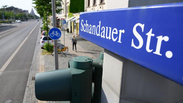 Ein Straßenschild "Schandauer Straße" ist in Dresden-Striesen über einer Ampel montiert. 