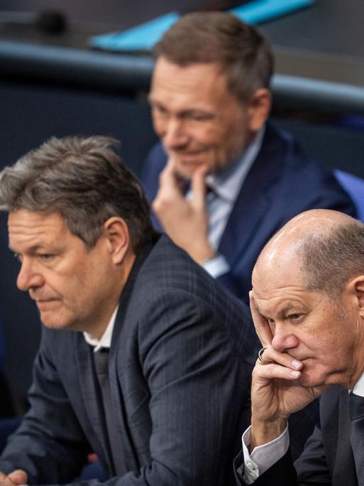 Olaf Scholz, Robert Habeck und Christian Lindner verfolgen die Debatte zum Auftakt der Haushaltswoche.