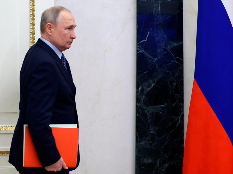 Der russische Präsident Wladimir Putin mit einer roten Mappe unter dem Arm, auf dem Weg zur einer Sitzung des Sicherheitsrats in Moskau. 