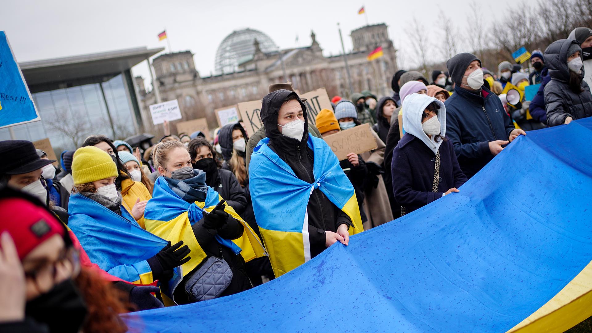 Menschen schwenken friedensfahnen und flaggen der ukraine