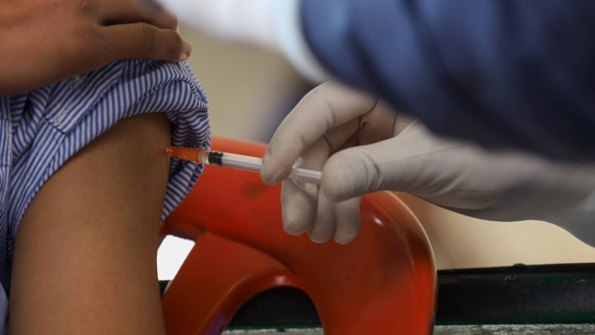 Ein Kind bekommt zwecks Masernimpfung eine Spritze in den Oberarm. 