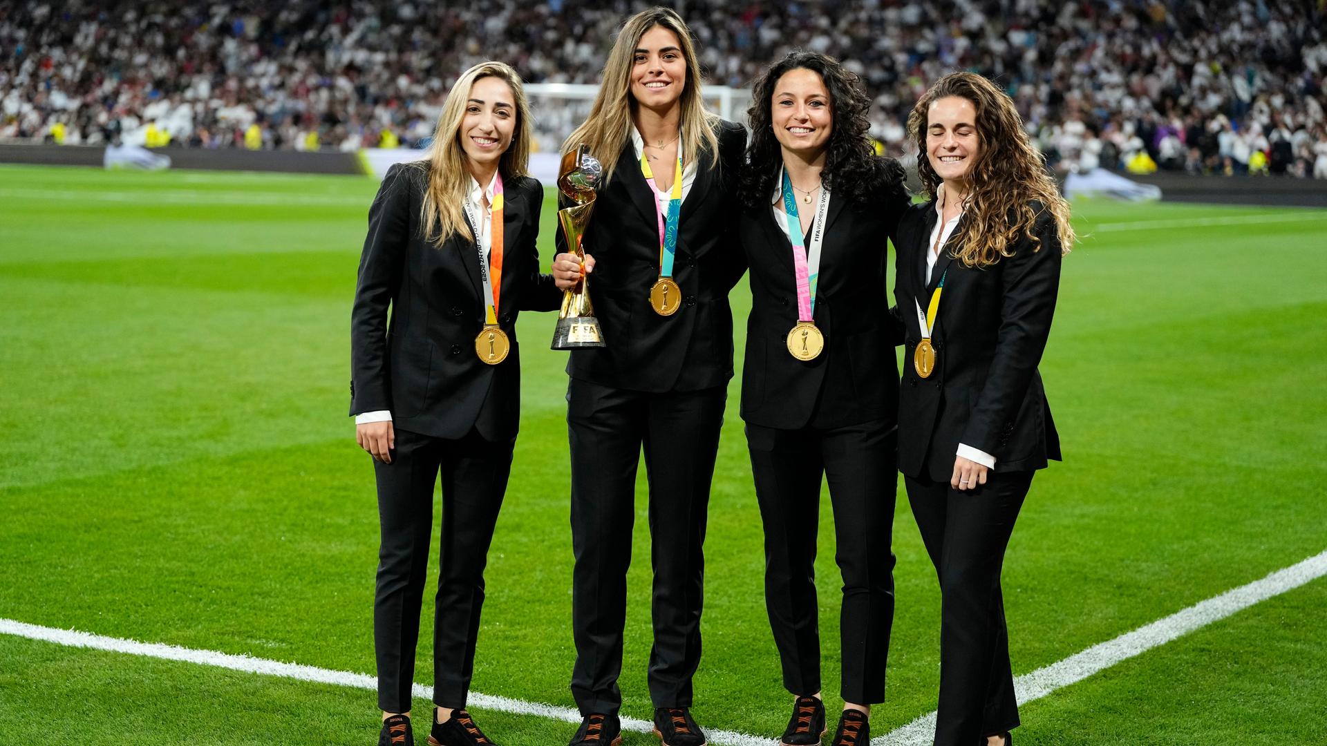 Olga Carmona (l-r), Misa Rodríguez, Ivana Andrés, Teresa Abelleira, alles Spielerinen der spanischen Nationalmannschaft, halten die Trophäe der Frauen-Weltmeisterschaft vor dem Spiel zwischen Real Madrid und Getafe im Santiago Bernabeu Stadion.