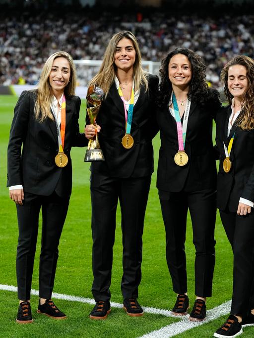 Olga Carmona (l-r), Misa Rodríguez, Ivana Andrés, Teresa Abelleira, alles Spielerinen der spanischen Nationalmannschaft, halten die Trophäe der Frauen-Weltmeisterschaft vor dem Spiel zwischen Real Madrid und Getafe im Santiago Bernabeu Stadion.