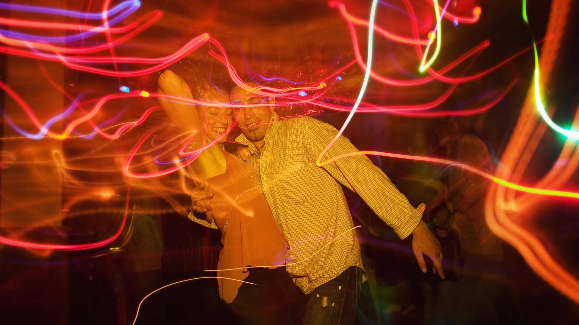 Ein Paar tanzt engumschlungen in einem Club.