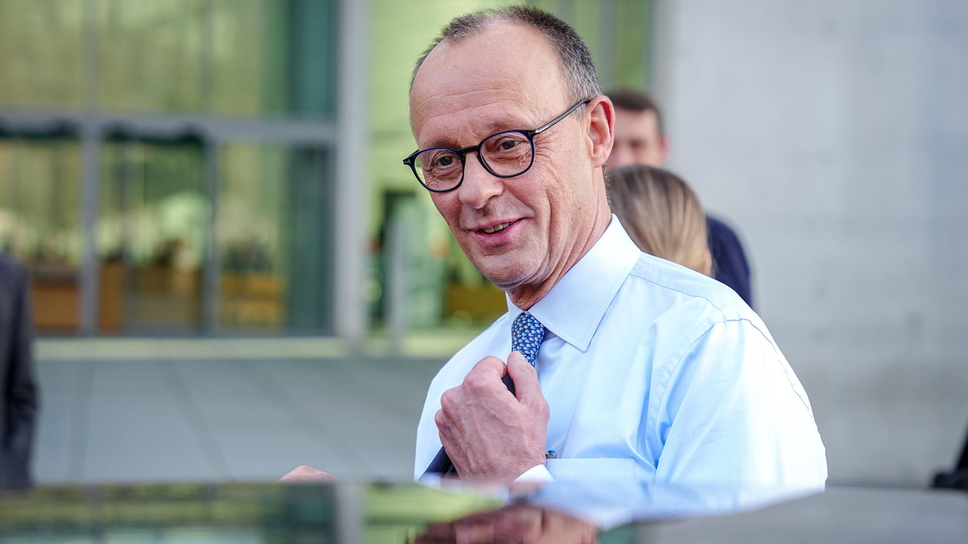 Friedrich Merz, Unions-Kanzlerkandidat und CDU-Bundesvorsitzender, steigt nach einer Pressekonferenz nach den Sondierungsgesprächen von Union und SPD im Bundestag lächelnd in eine Limousine.