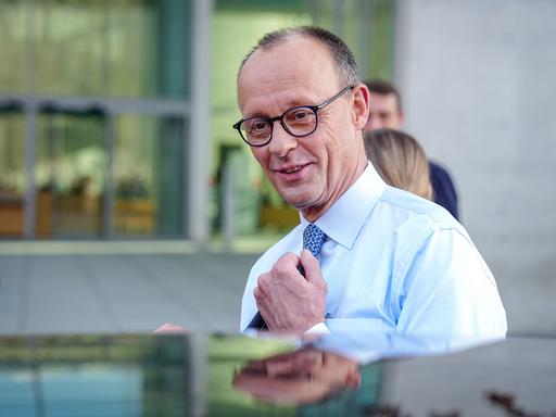 Friedrich Merz, Unions-Kanzlerkandidat und CDU-Bundesvorsitzender, steigt nach einer Pressekonferenz nach den Sondierungsgesprächen von Union und SPD im Bundestag lächelnd in eine Limousine.