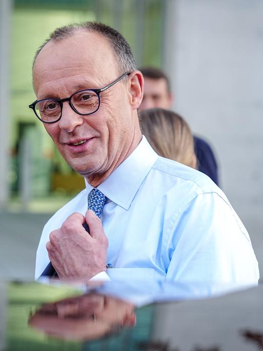 Friedrich Merz, Unions-Kanzlerkandidat und CDU-Bundesvorsitzender, steigt nach einer Pressekonferenz nach den Sondierungsgesprächen von Union und SPD im Bundestag lächelnd in eine Limousine.