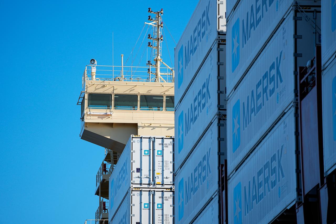 Ein Containerschiff des Logistikunternehmens Maersk von der Seite. Zu sehen sind mehrere Container.