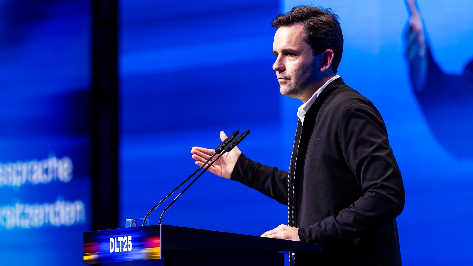 Johannes Winkel (CDU), Bundesvorsitzender der Jungen Union (JU), steht im dunklen Anzug an einem Rednerpult. 
