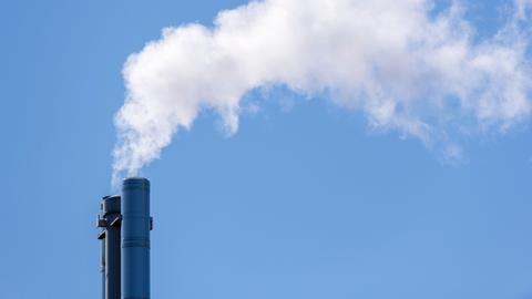 Rauchender Industrieschlot eines Fernheizkraftwerks