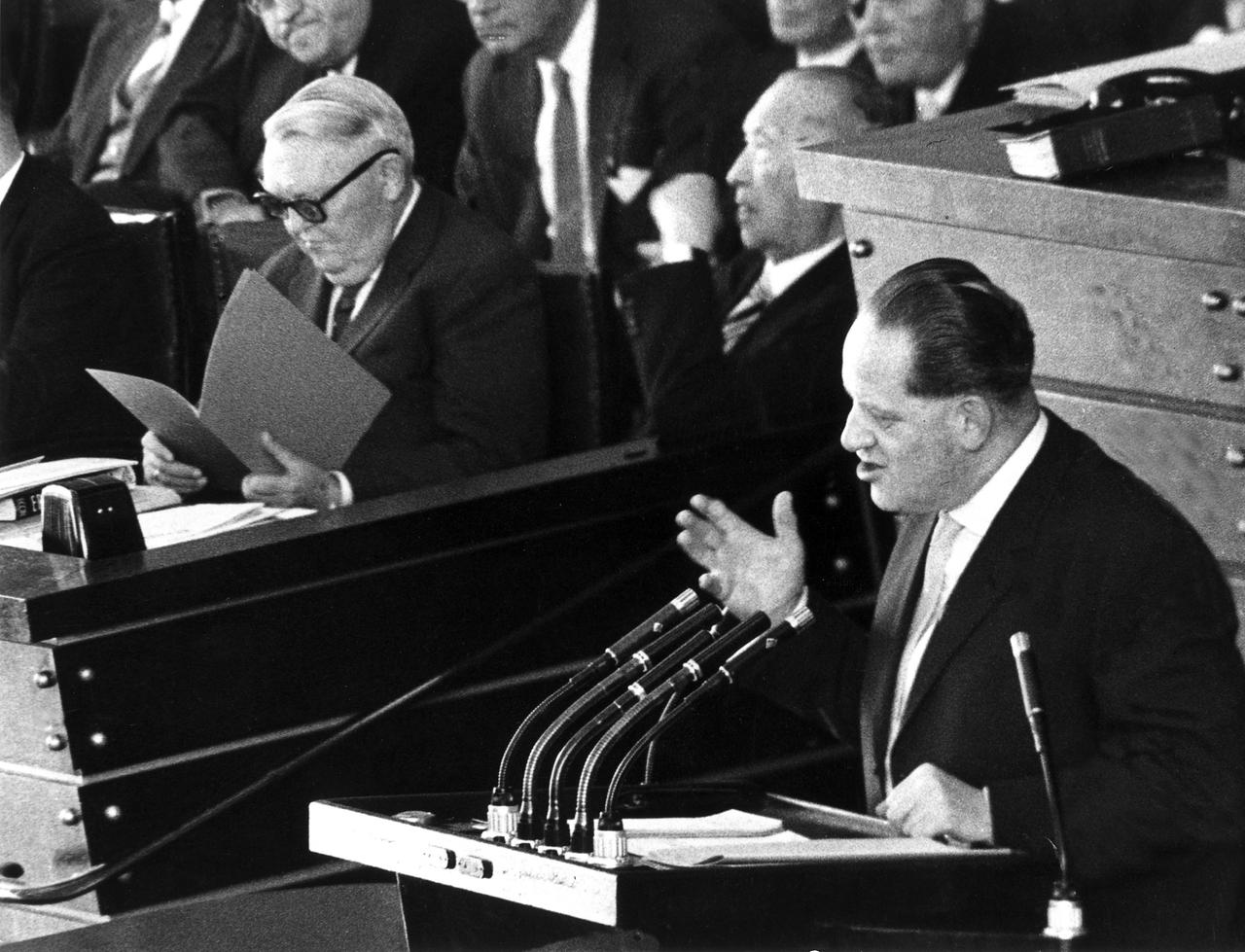 Herbert Wehner (SPD) bei seiner viel beachteten Rede während der außenpolitischen Debatte am 30.06.1960 im Deutschen Bundestag in Bonn. Links hinter Wehner Bundeskanzler Konrad Adenauer (CDU), ganz links Bundeswirtschaftsminister und Vizekanzler Ludwig Erhard (CDU).