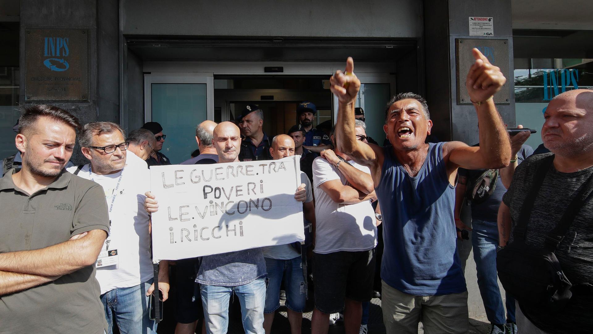 Italien, Neapel: Menschen protestieren mit einem Banner gegen die Streichung der Sozialhilfen.