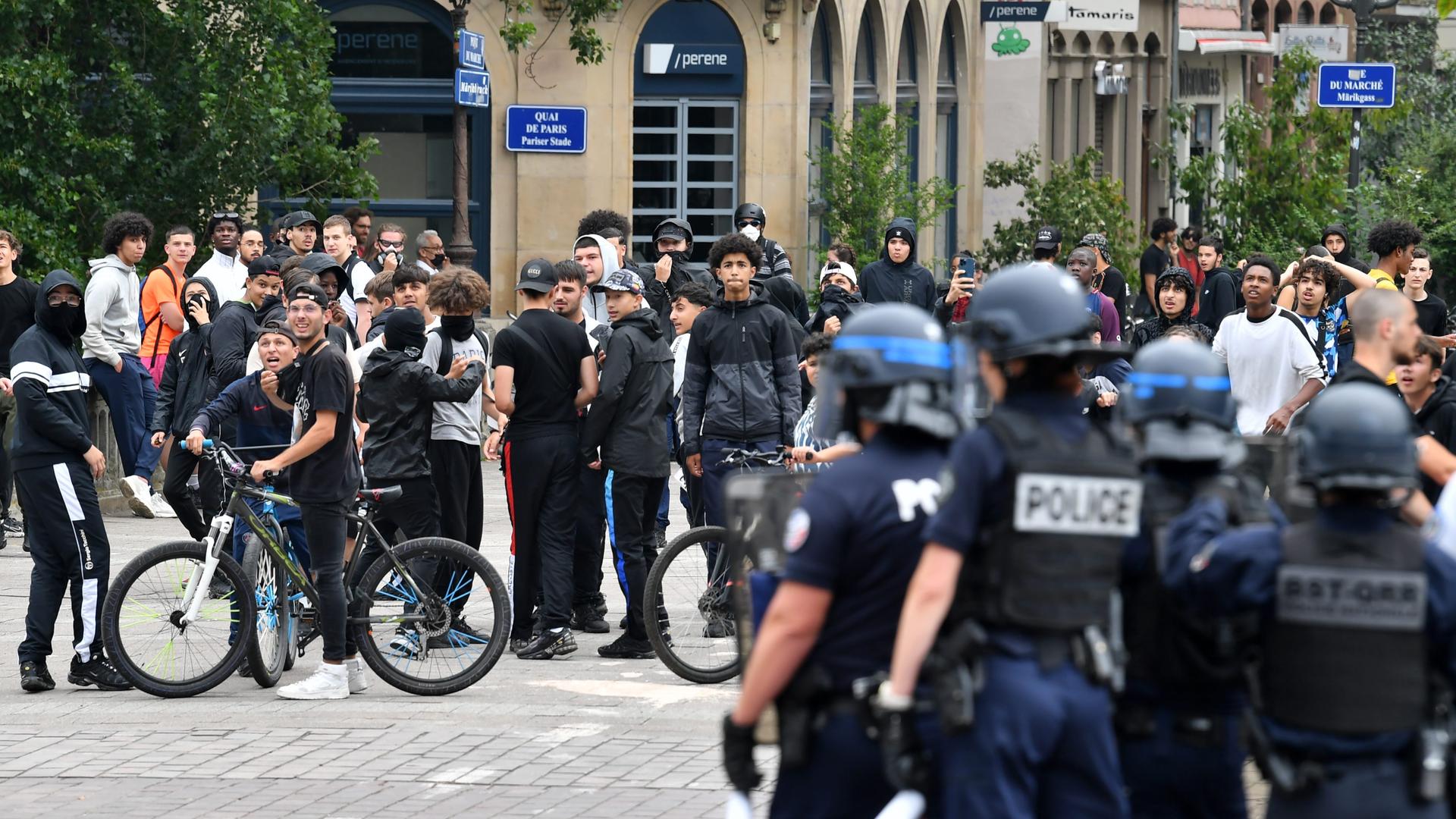 In Strasbourg stehen sich eine Gruppe Jugendlicher - viele von ihnen deutliche unter 20 - und Polizeieinheiten gegenüber.