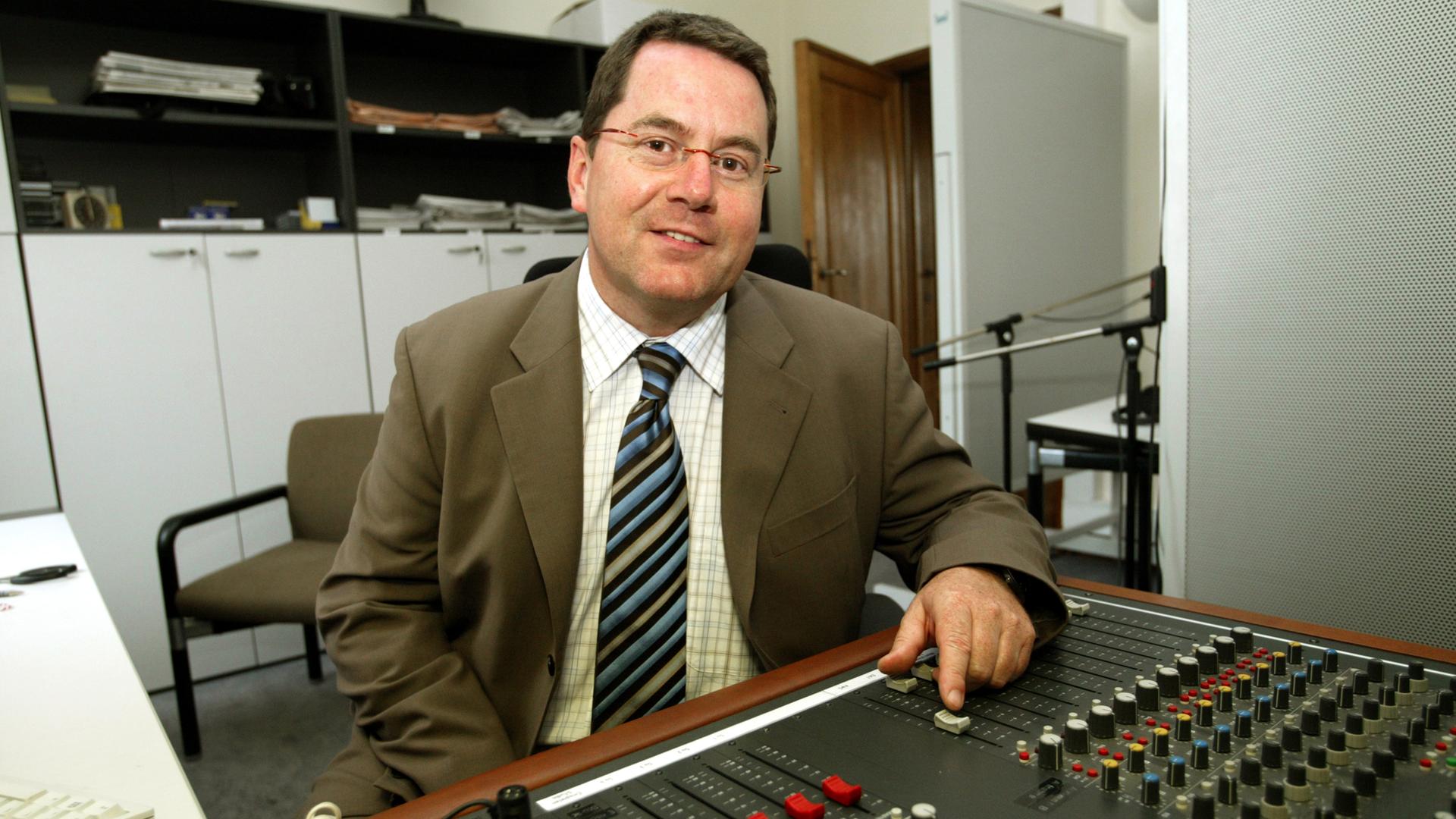 Der Korrespondent Peter Kapern sitzt in einem Brüsseler Studio vor einem Mischpult.