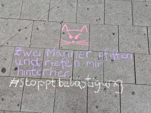 "Zwei Männer pfiffen und riefen mir hinterher - #stoppbelästigung" steht mit Kreide geschrieben.