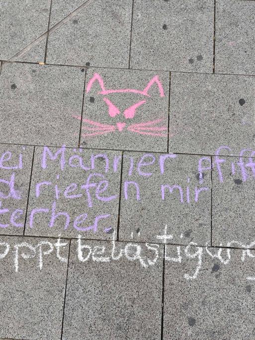 "Zwei Männer pfiffen und riefen mir hinterher - #stoppbelästigung" steht mit Kreide geschrieben.