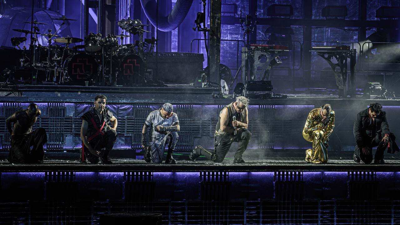 Die Mitglieder der deutschen Metal-Band Rammstein sind auf der Bühne während eines Konzerts zu sehen. Die Atmosphäre ist typisch für deren Auftritte dunkel und düster.