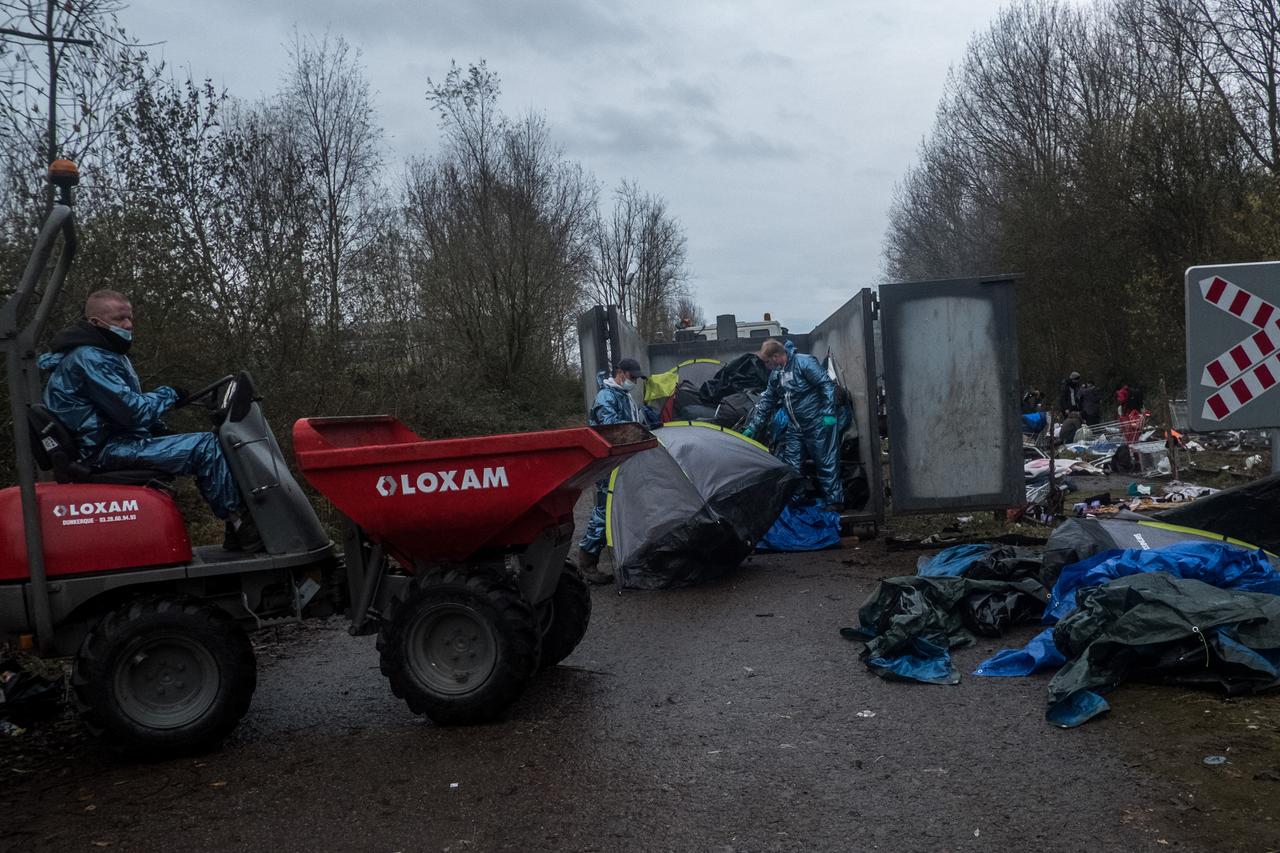 In Loon-Plage, zwischen Calais und Dünkirchen, entsorgen Einsatzkräfte Zelte eines Lagers in Container.