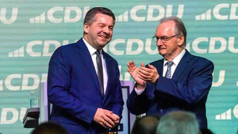 Reiner Haseloff (r), Ministerpräsident des Landes Sachsen-Anhalt, applaudiert auf dem Landesparteitag der CDU Sachsen-Anhalt Sven Schulze (l), Vorsitzender der CDU Sachsen-Anhalt.