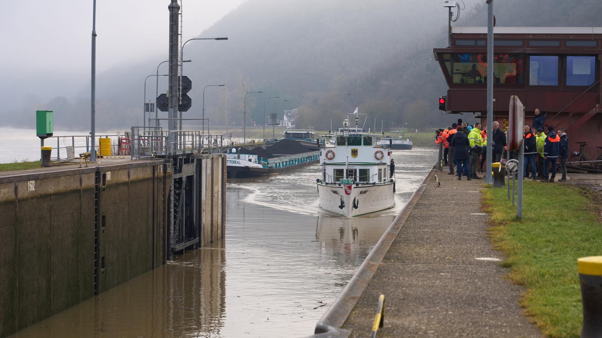 Ein Schiff, unter anderem mit Bundesverkehrsminister Wissing an Bord, fährt in die Schleusenkammer der nach einer Havarie reparierten Moselschleuse Müden ein.
