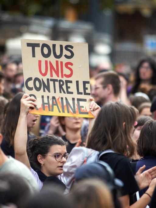 Eine Frau hält bei einer Demonstration am 1.7.2024 in Toulouse ein Schild mit der Aufschrift "Alle vereint gegen den RN".