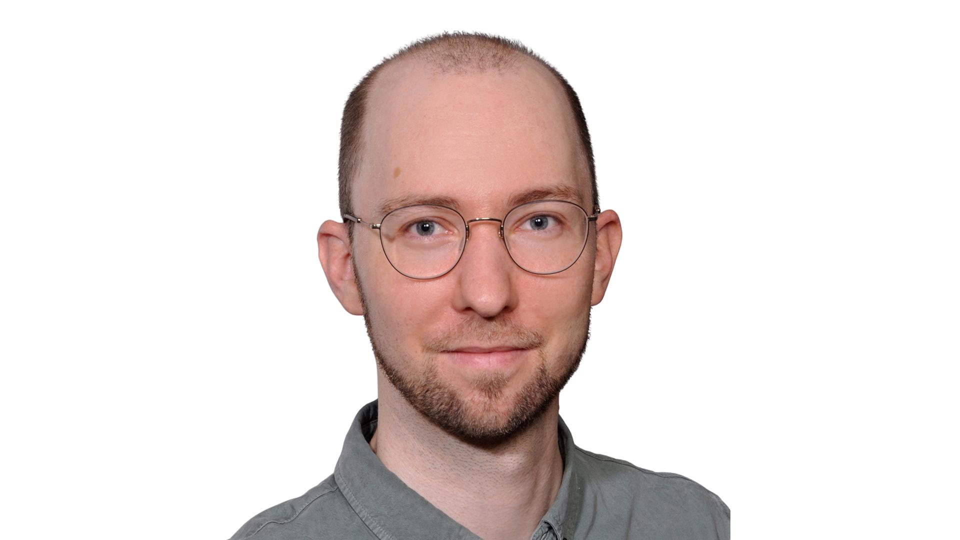 Portrait-Foto eines jungen Mannes mit Brille und grauem Hemd Portrait-Foto eines jungen Mannes mit Brille und grauem Hemd