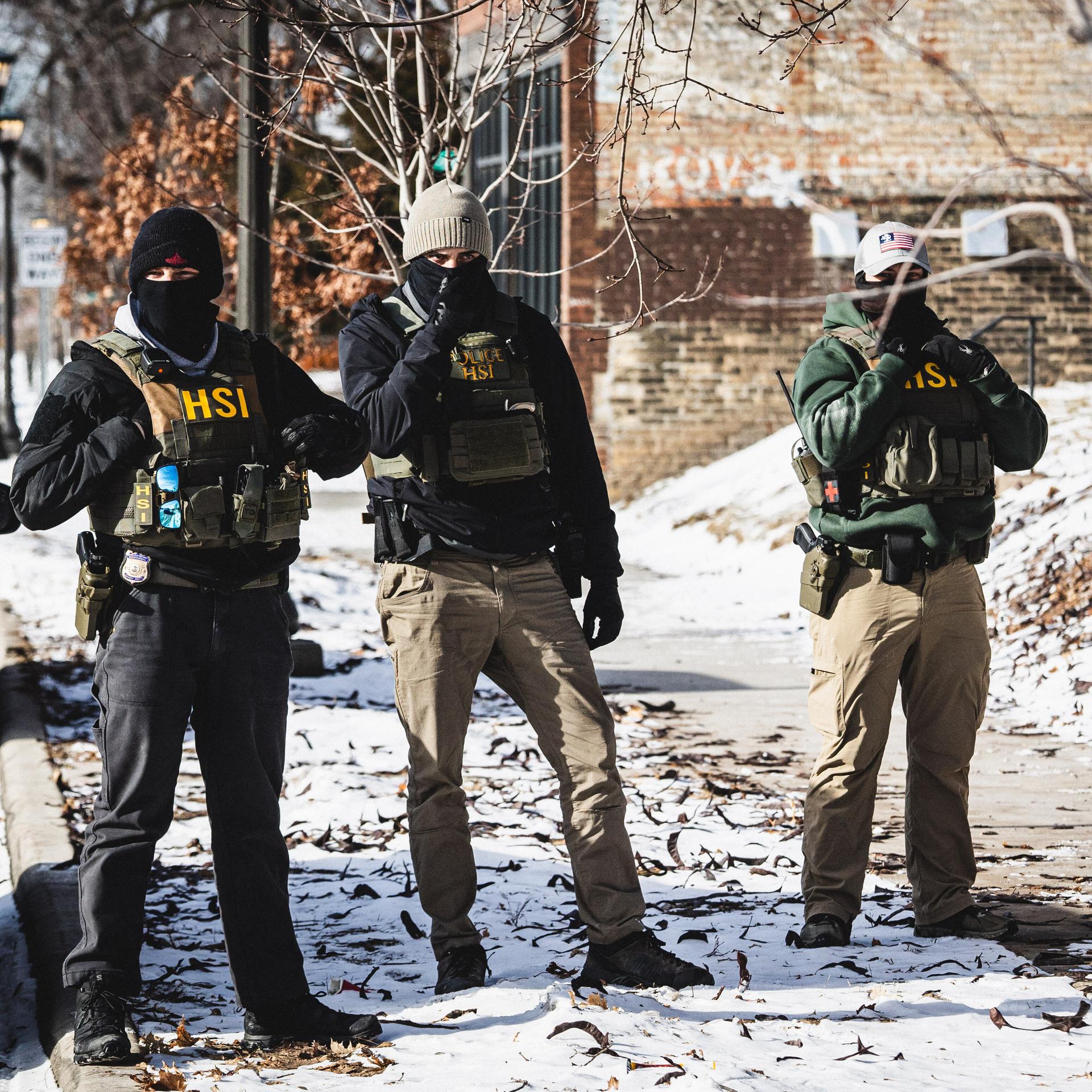 Beamte der Einwanderungs- und Zollbehörde ICE gehen in St. Paul, Minnesota, auf der Straße. 