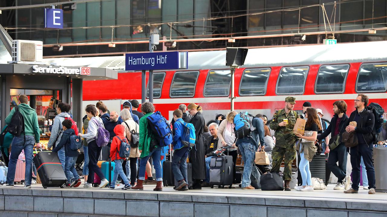 Viele Fahrgäste warten am Hamburger Hauptbahnhof vor einem Service Store der Deutschen Bahn am Gleis auf ihren Zug.