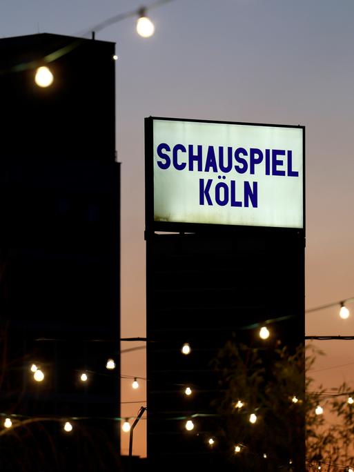 Der abendliche Blick auf ein Schild des Schauspiel Köln am Schauspiel Köln im Depot. 