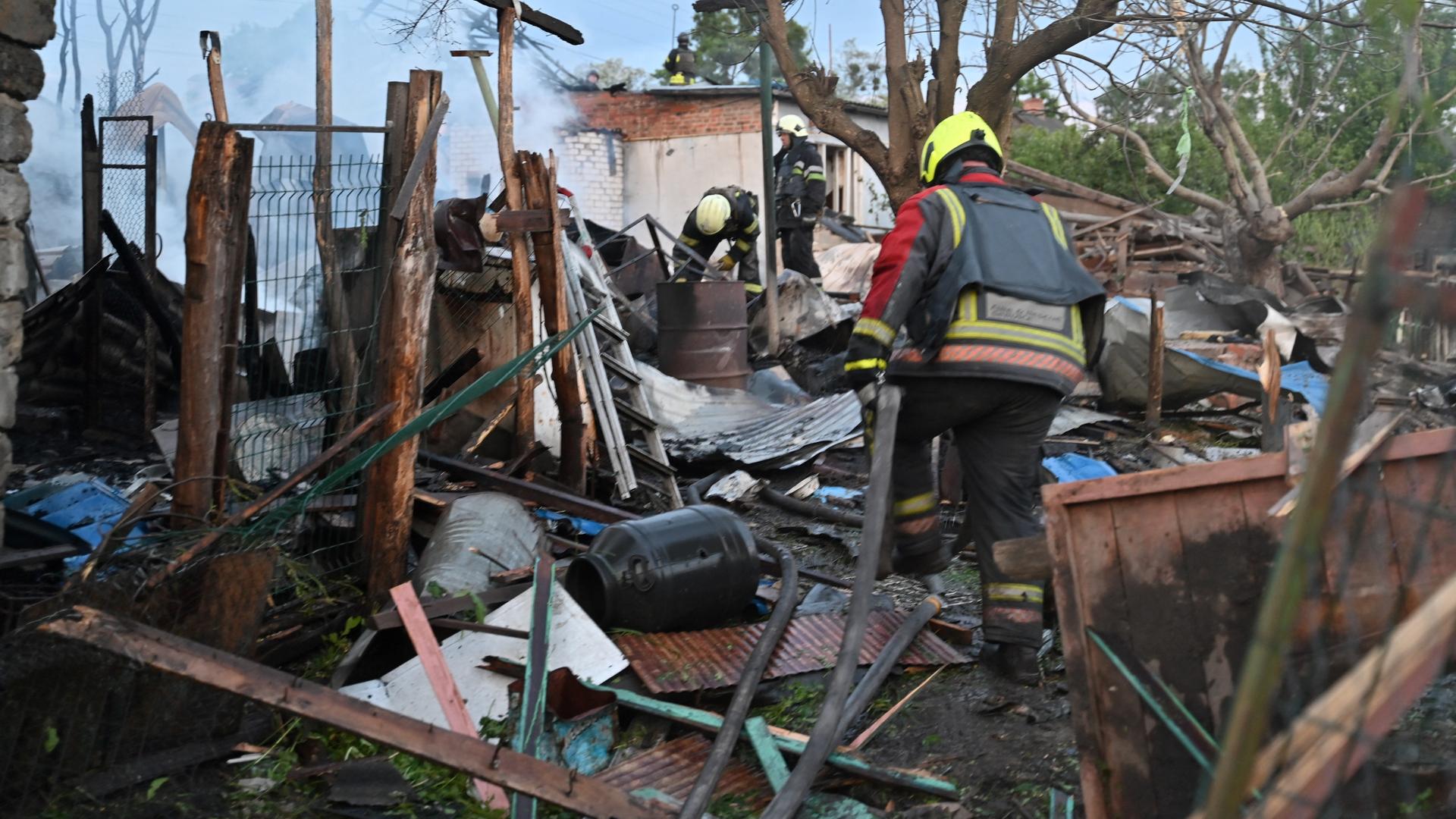 Feuerwehrleute untersuchen ein von russischen Kampfdrohnen zerstörtes Haus in Charkiw in der Ukraine.