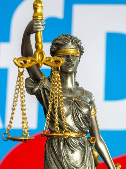 Die Bronzestatue der Justitia vor dem Logo der AfD – Symbolbild für den Rechtsstreit um die Einstufung der Partei als "gesichert rechtsextremistisch".
