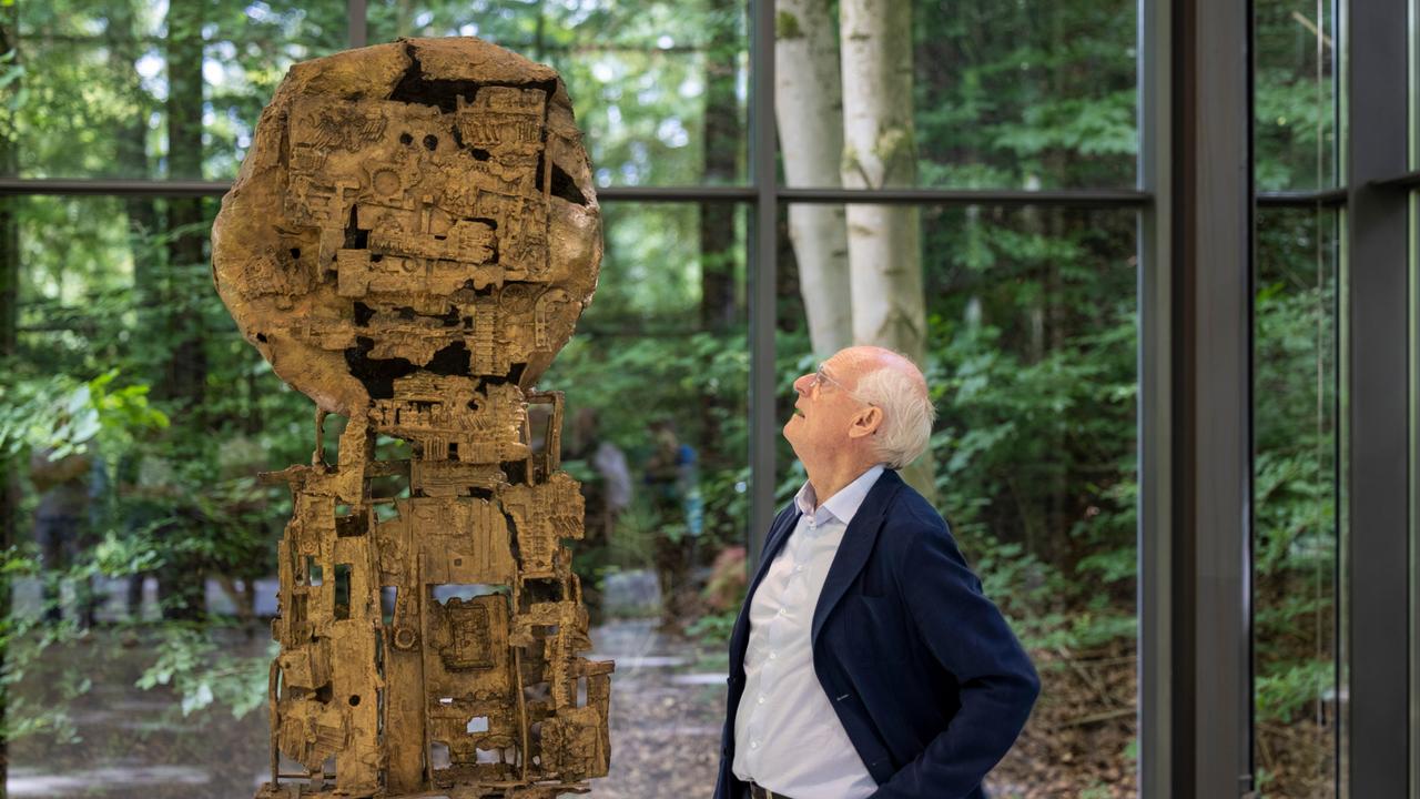 Tony Cragg, Künstler und Bildhauer, steht im Skulpturenpark in einer Ausstellungshalle an der Skulptur "St. Sebastian IV" des Künstlers Eduardo Paolzozzi.
