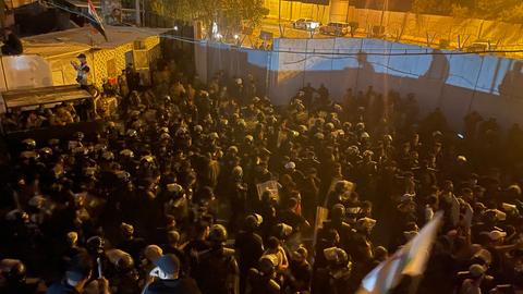 Das Foto zeigt Demonstrierende auf dem Dach eines Gebäudes neben der schwedischen Botschaft in Bagdad. Es ist Nacht.