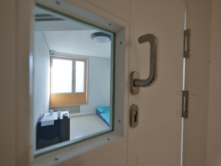 Ein Intensiv-Zimmer ist im Zentrum für Psychiatrie in Weißenau (ZfP) menschenleer. Die Tapete wurde teils abgerissen. Der Blick ins Zimmer ist durch die Sichtscheibe in der Tür möglich.