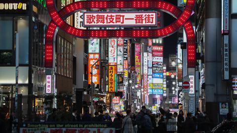 Das Foto zeigt den rot beleuchteten Kabukicho-Ichibangai-Bogen in Kabukicho, Japans größtem Ausgehviertel, im Tokioter Bezirk Shinjuku. 