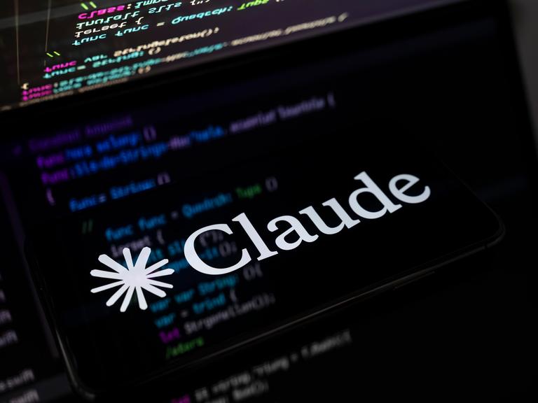 Auf einem Smartphone ist das Logo des Chatbot Claude abgebildet. 