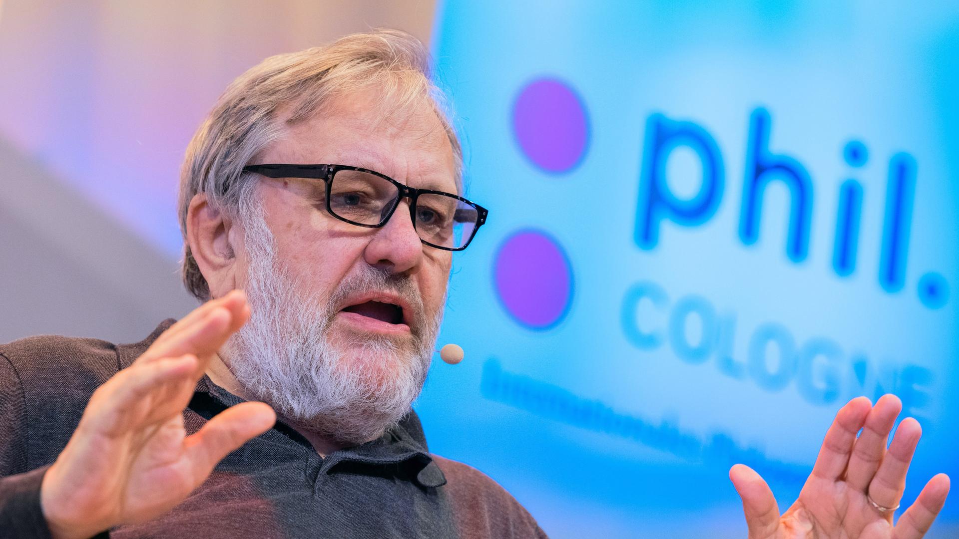 Slavoj Zizek, slowenischer Philosoph, spricht bei der Eröffnung der Phil.Cologne. Im Hintergrund das Logo der Veranstaltung. Slavoj Zizek, slowenischer Philosoph, spricht bei der Eröffnung der Phil.Cologne. Im Hintergrund das Logo der Veranstaltung.