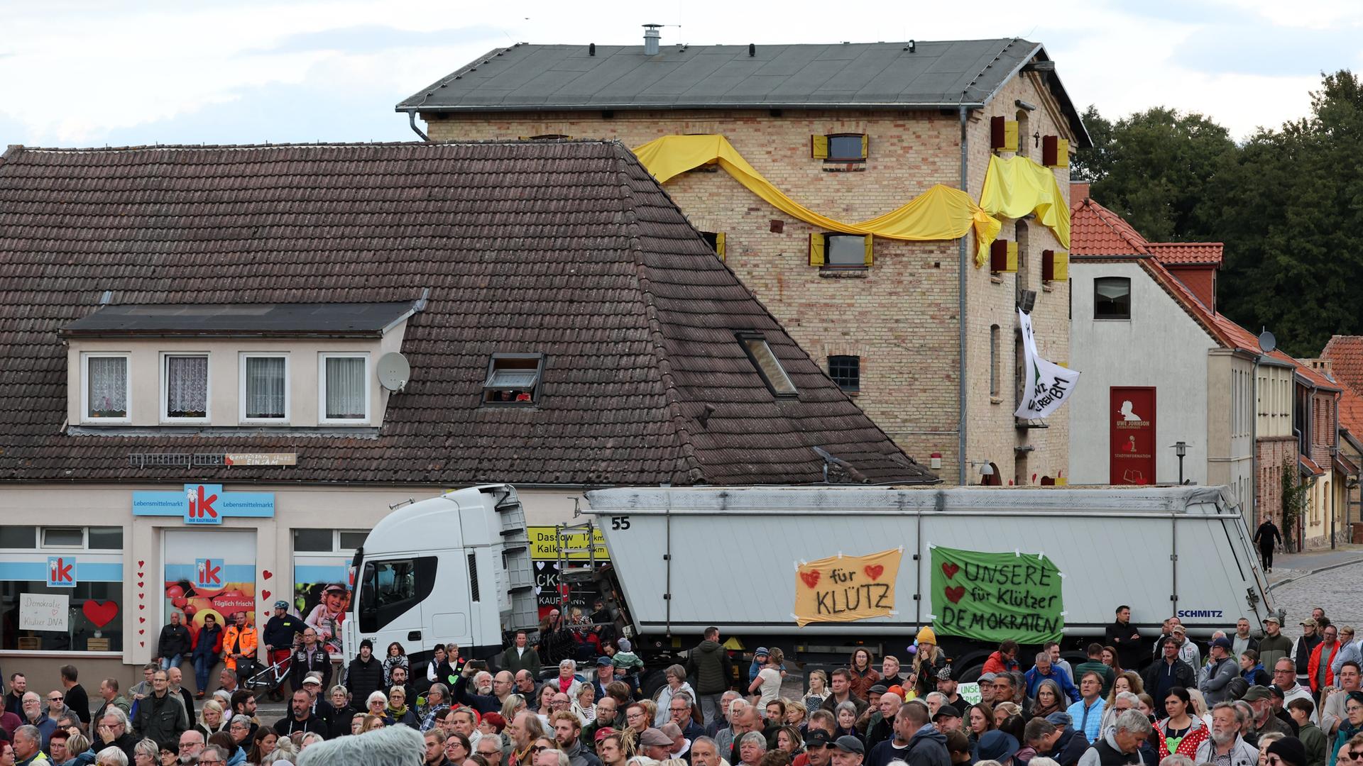 Zahlreiche Menschen nehmen an einer Kundgebung auf dem Markt teil, zu der die Autorenvereinigung Pen Berlin aufgerufen hat. Im Hintergrund ist das Literaturhaus mit gelben Bannern zu sehen.