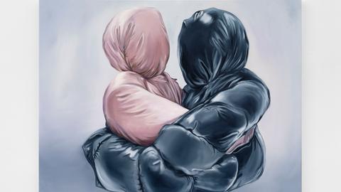 Zwei sich umarmende Gestalten, eine in einer rosa und eine in einer schwarzen Daunenjacke, die jeweils auch die Köpfe verhüllt