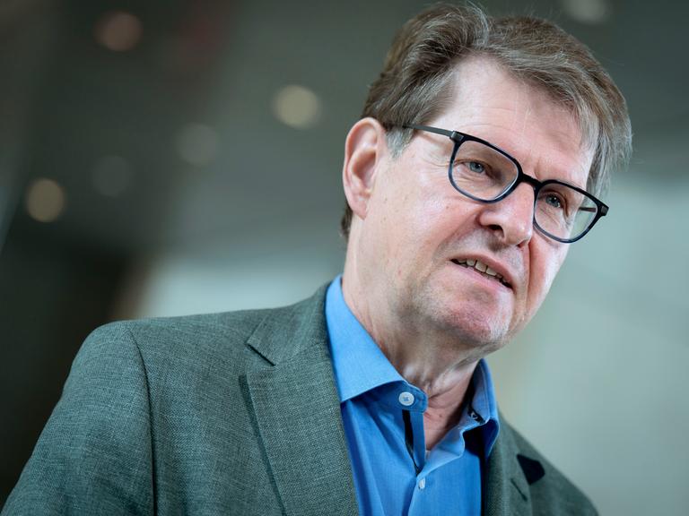 Der SPD-Politiker Ralf Stegner steht im Reichstagsgebäude in Berlin, trägt zum blauen Hemd ein graues Jackett und spricht.