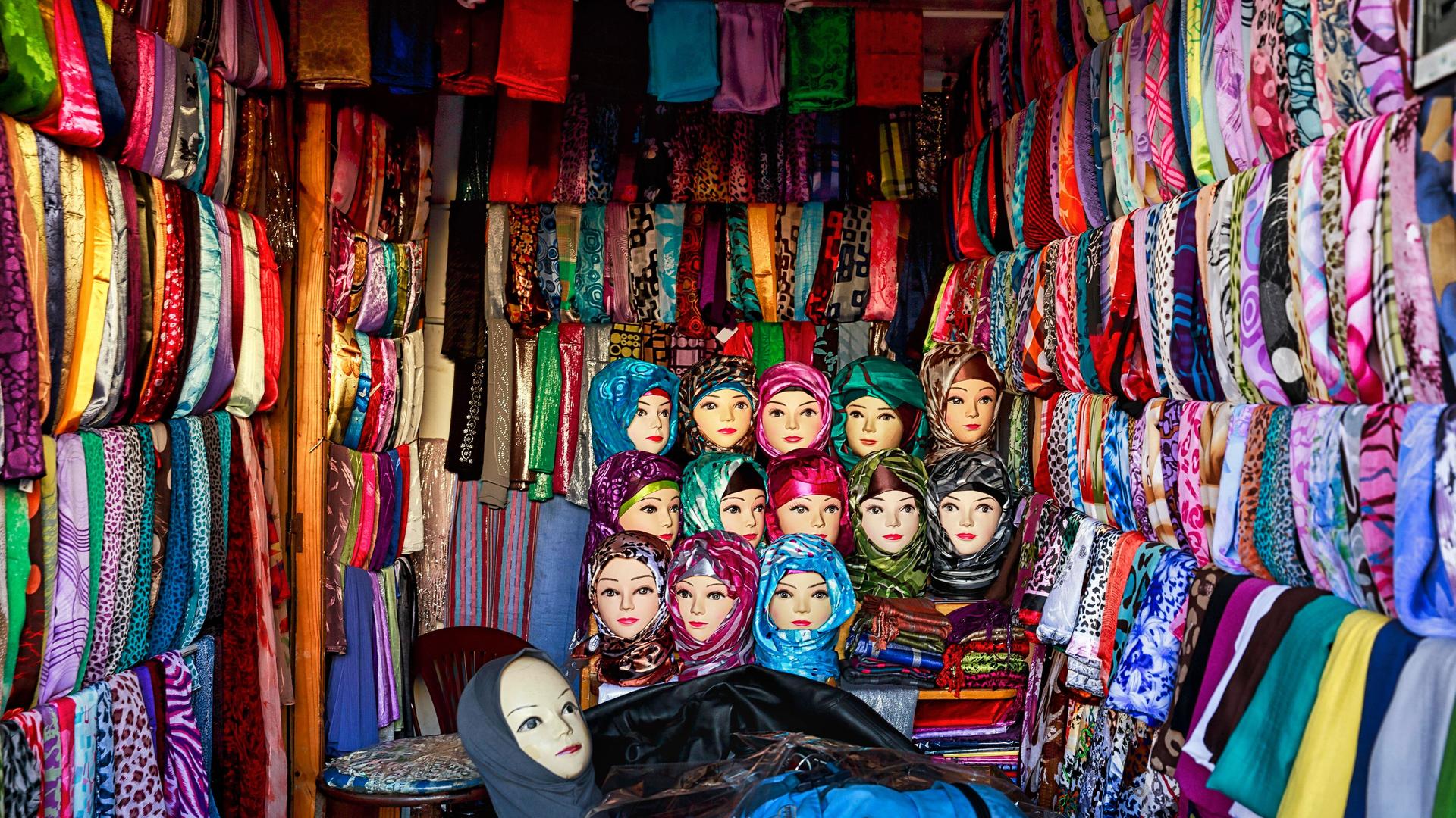Viele bunte Kopftücher und Köpfe von Modepuppen an einem Marktstand in Fes, Marokko, Afrika