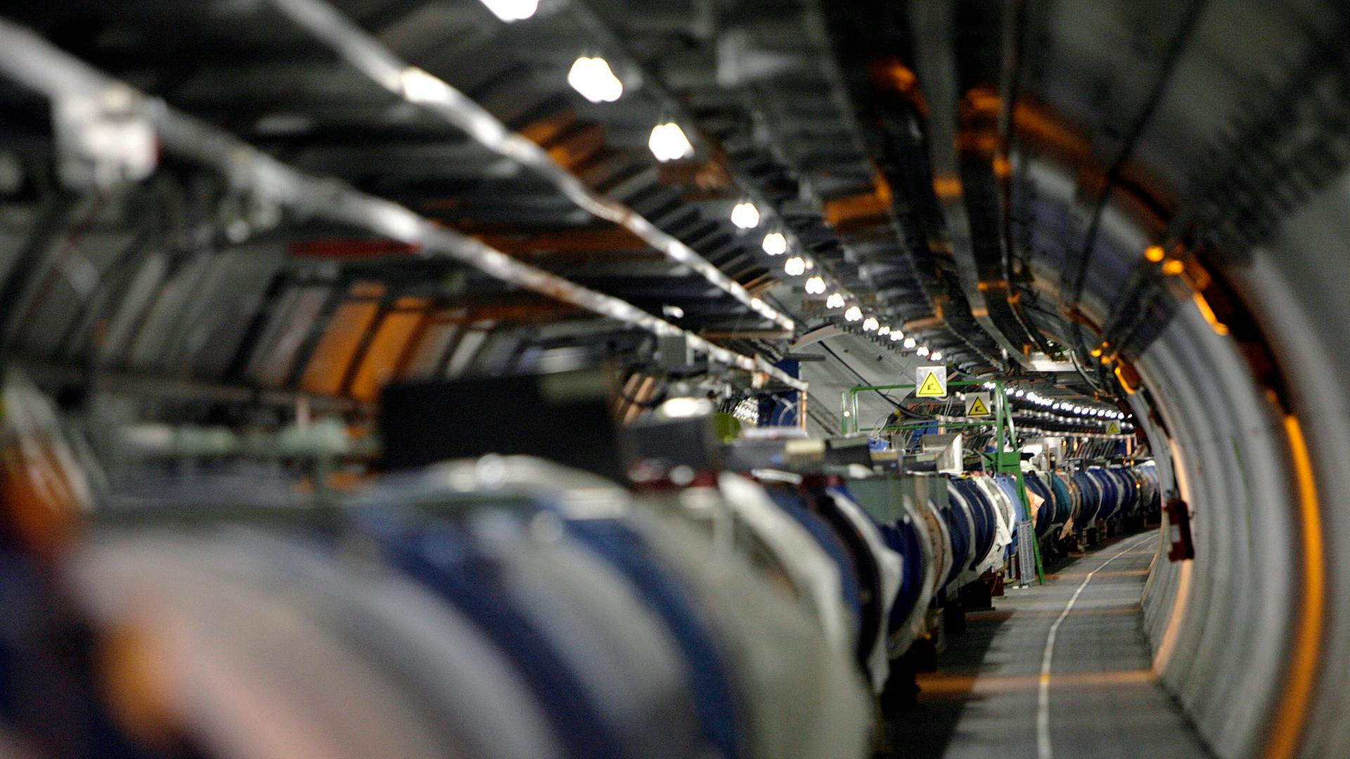 Blick einen Gang mit Geräten entlang: der Large Hadron Collider am CERN in der Schweiz.