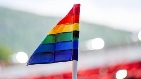 Eine Eckfahne in Regenbogenfarben in einem Fußballstadion.