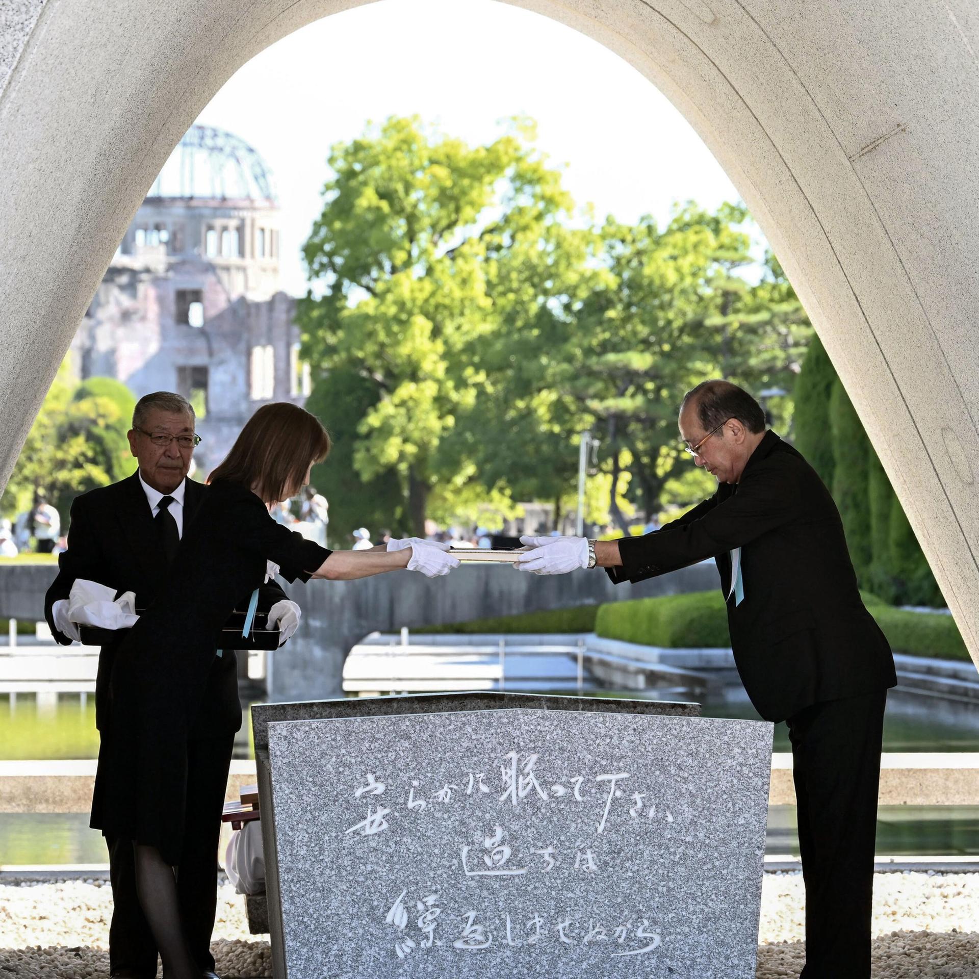 Hiroshimas Bürgermeister Matsui legt eine Liste der Opfer auf  ein leeres Grab im Peace Memorial Park.