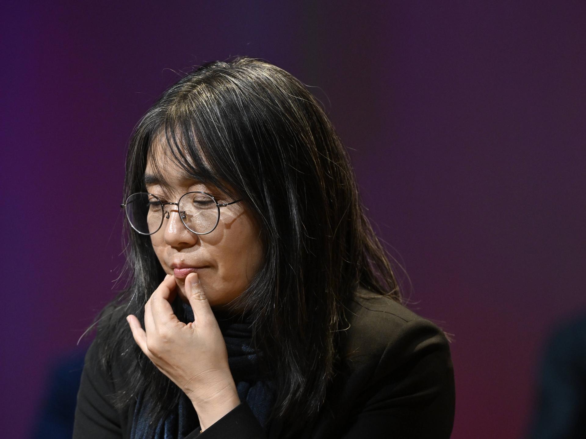 Autorin Han Kang, die sich in nachdenklicher Pose an die Lippe fasst Autorin Han Kang, die sich in nachdenklicher Pose an die Lippe fasst