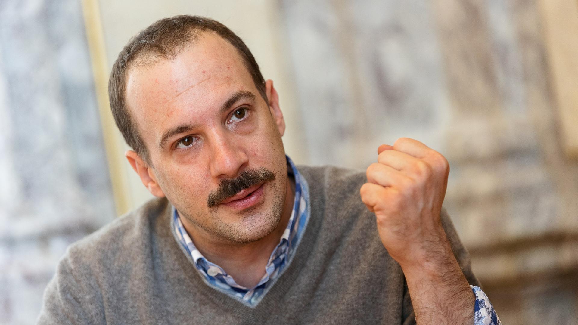 Florian Teichtmeister, ein Mann in mittlerem Alter mit dunklem Schnurrbart und hoher Stirn, hat die linke Hand zur Faust geballt. Florian Teichtmeister, ein Mann in mittlerem Alter mit dunklem Schnurrbart und hoher Stirn, hat die linke Hand zur Faust geballt.